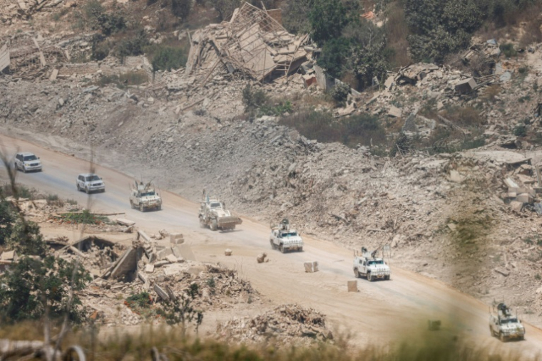 Des véhicules blindés de la Finul circulent au milieu de bâtiments détruits dans le sud du Liban, le 22 juillet 2026 ( AFP / Jalaa MAREY )