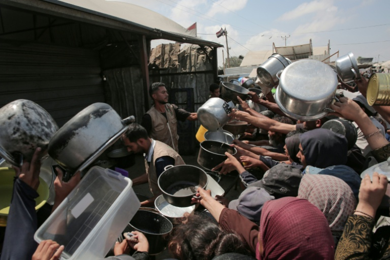 Des Palestiniens se pressent à une distribution de nourriture dans une cantine de campagne à Khan Younès, dans le sud du territoire palestinien où l'ONU a déclaré la famine, le 21 août 2025 ( AFP / - )