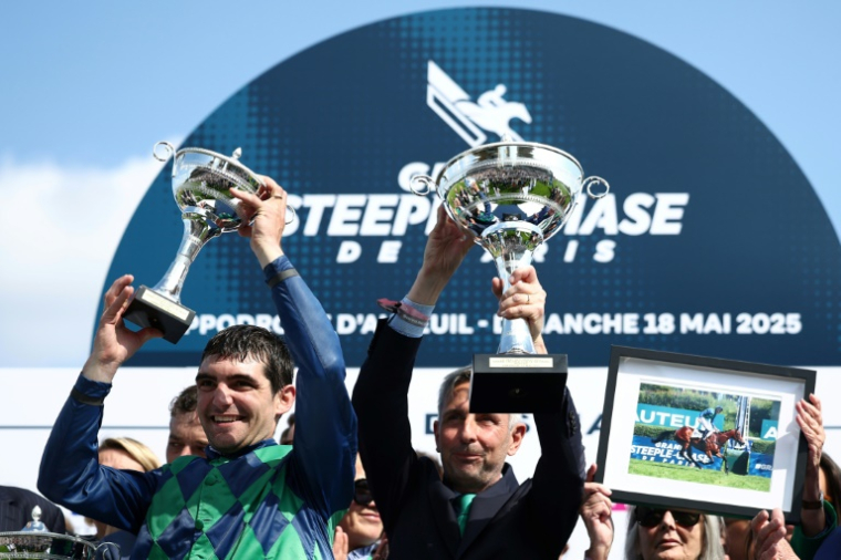 Le jockey français Clément Lefebvre (g) et le propriétaire de "Diamond Carl", Xavier Papot, sur le podium, après avoir remporté la 147e édition du Grand Steeple-Chase de Paris, à l'Hippodrome d'Auteuil à Paris, le 18 mai 2025 ( AFP / Anne-Christine POUJOULAT )