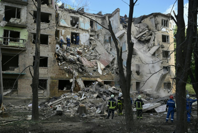Des équipes de secours devant un immeuble résidentiel touché par une frappe russe à Kiev, le 23 juin 2025 en Ukraine ( AFP / Genya SAVILOV )