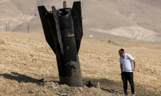 Un Israélien inspecte une roquette tombée, à moitié enfouie dans le sol, en périphérie de Jéricho en Cisjordanie, le 8 juin 2026. ( AFP / Ahmad GHARABLI )