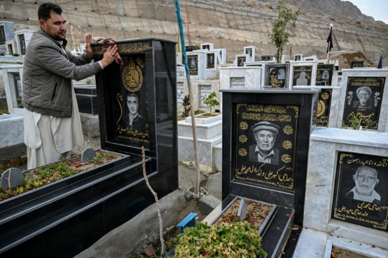 Talib Hussain nettoie la pierre tombale sur laquelle est gravé le portrait de son père décédé, dans un cimetière de Quetta, au Pakistan, le 17 février 2026 ( AFP / Banaras KHAN )