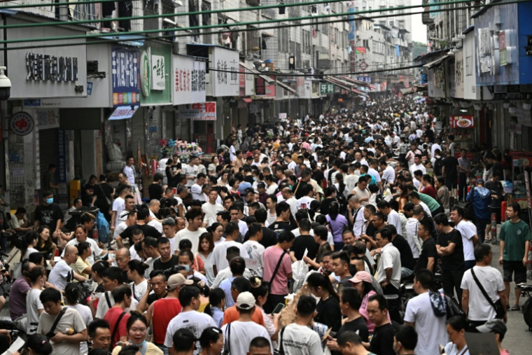 Demandeurs d'emplois et recruteurs se mêlent dans un village proche de Canton, en Chine, le 27 avril 2026 ( AFP / Pedro PARDO )