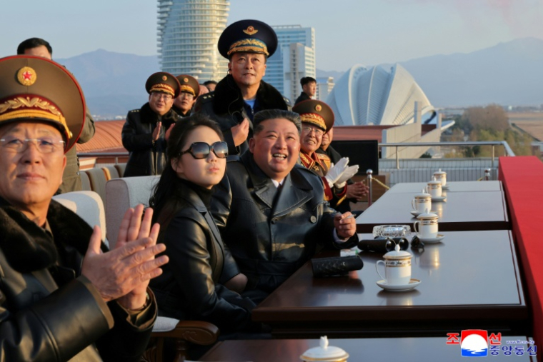Photo prise le 28 novembre 2025 et diffusée par l'agence de presse officielle nord-coréenne KCNA le 30 novembre 2025, montrant le dirigeant nord-coréen Kim Jong Un (3e g) et sa fille Ju Ae (2e g) assistant à un vol de démonstration commémorant le 80e anniversaire de la fondation de l'Armée de l'air de l'Armée populaire de Corée, sur l'aérodrome de Kalma à Wonsan, dans la province de Gangwon ( KCNA VIA KNS / STR )