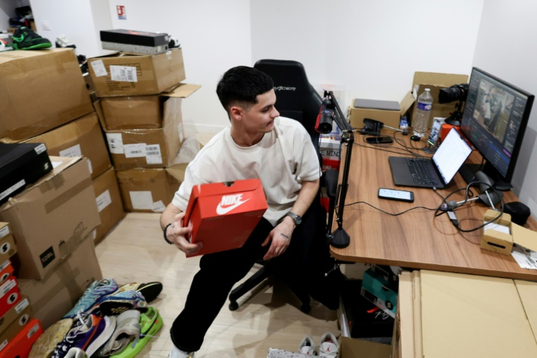 Le fondateur de la boutique Swave, Hugo Carvalho, lors d'une vente en live de sneakers, le 12 mars 2026 à Paris ( AFP / ALAIN JOCARD )