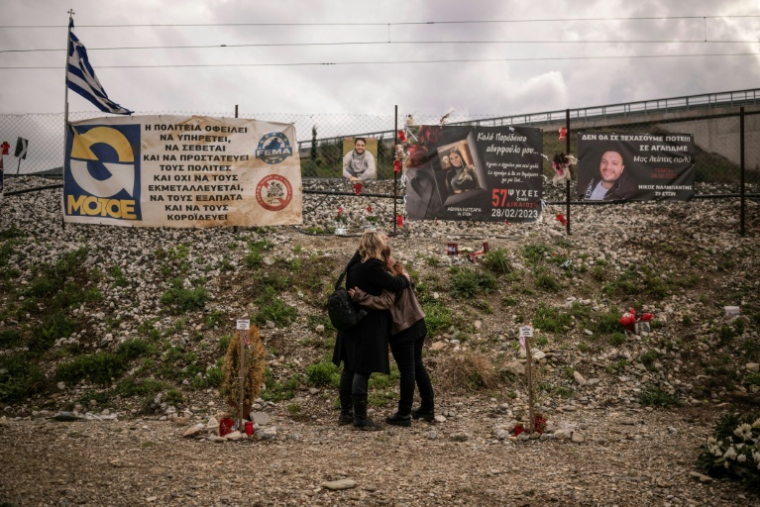 Des proches des victimes de la collusion entre deux trains le 28 février 2023, s'étreignent lors d'une cérémonie commémorative sur le site de l'accident dans la vallée de Tempi en Grèce, au nord de la ville centrale de Larissa, le 28 février 2024 ( AFP / Angelos TZORTZINIS )