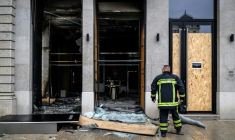 Un pompier devant les vitrines brisées d'un commerce, pillé et vandalisé, au lendemain d'une manifestation contre la vie chère à Lyon, le 18 octobre 2026 ( AFP / JEFF PACHOUD )