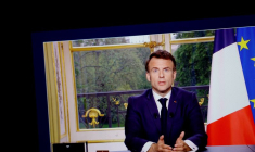Le président français Emmanuel Macron apparaît sur un écran, alors qu'il s'exprime lors d'un discours