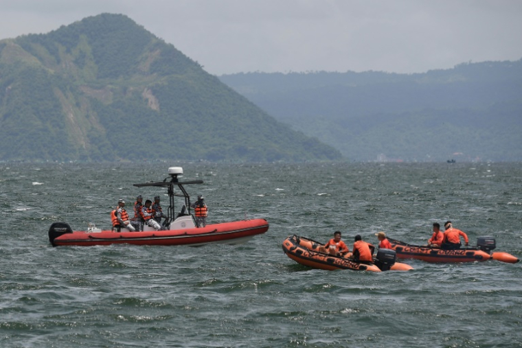 Des garde-côtes partent vers le site où les corps de personnes liées à l'industrie des combats de coqs auraient été jetés dans le lac Taal, au sud de Manille, le 10 juillet 2025 aux Philippines ( AFP / Ted ALJIBE )