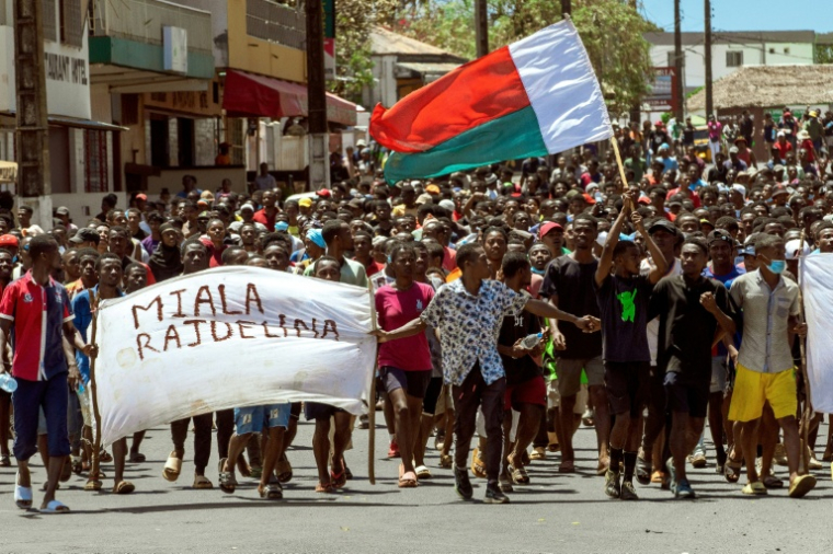 Des manifestants malgaches à Antsiranana brandissent le drapeau national et une banderole appelant le président Andry Rajoelina à partir, à Antananarivo le 1er octobre 2025 ( AFP / FITA )