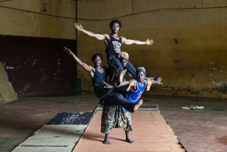 Mamadou Saliou Diallo (en haut), Ibrahima Oulare (g), Alassane Toinnkara (d) et Mohamed Camara (c) lors d'un entraînement au centre d'art acrobatique Fodéba Keïta, le 6 septembre 2025 à Conakry, en Guinée ( AFP / PATRICK MEINHARDT )