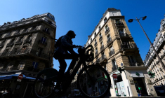 Un homme roule à vélo près de l'endroit où un gang masqué a tenté d'enlever la fille d'un crypto-entrepreneur, à Paris