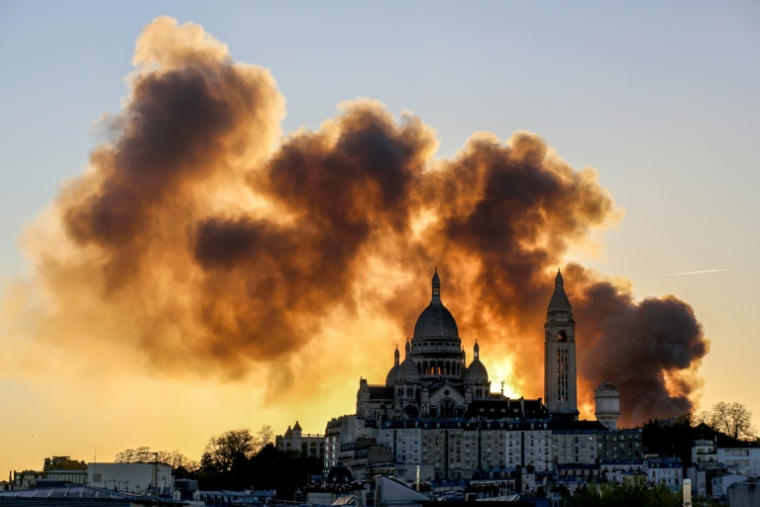 Un nuage de fumée derrière la basilique du Sacré-Cœur alors qu'un important incendie s'est déclaré dans le 17e arrondissement, dans le nord de Paris, le 7 avril 2025 ( AFP / Idhir BAHA )