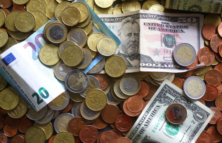 Une image d'illustration montre des billets et des pièces en euros et en dollars américains
