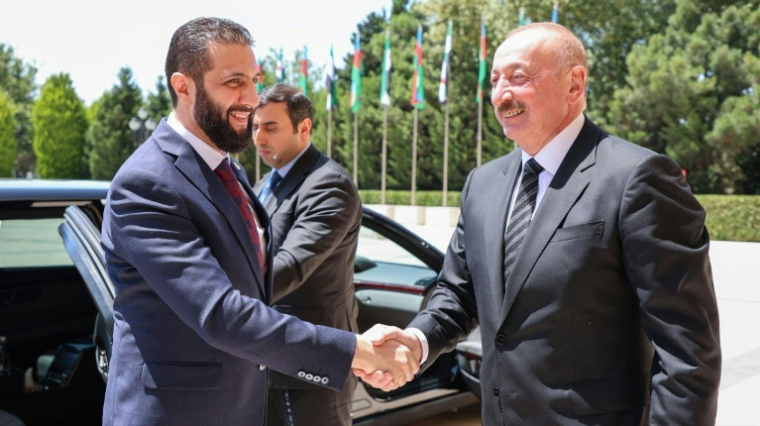 Une photo publiée par la présidence syrienne montre le président azerbaïdjanais Ilham Aliyev (D) recevant le président par intérim syrien Ahmad al-Chareh à Bakou, le 12 juillet 2025 ( Syrian Presidency / - )