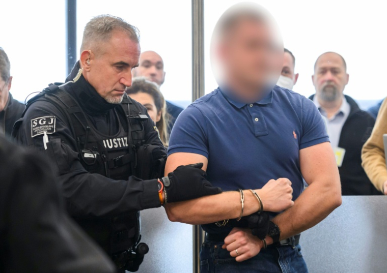 L'accusé Paul M. est amené devant le tribunal de Dresde au premier jour du procès du groupe d'extrême gauche Antifa Ost, le 25 novembre 2025 à Dresde ( POOL / MATTHIAS RIETSCHEL )