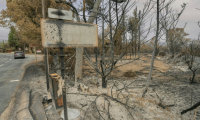 Un panneau d'entrée de la ville de Durban-Corbières, dans l'Aude, après le passage de l'incendie, le 9 août 2025 ( AFP / Idriss Bigou-Gilles )