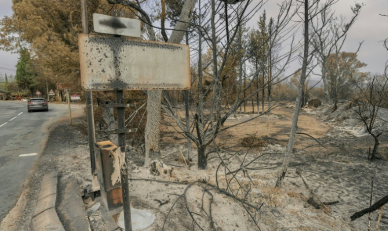 Un panneau d'entrée de la ville de Durban-Corbières, dans l'Aude, après le passage de l'incendie, le 9 août 2025 ( AFP / Idriss Bigou-Gilles )