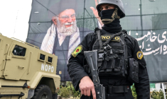 Un membre des forces de sécurité iraniennes monte la garde à côté d'une banderole rendant hommage au guide suprême iranien assassiné, l'ayatollah Ali Khamenei, le 31 mars 2026 à Téhéran  ( AFP / ATTA KENARE )