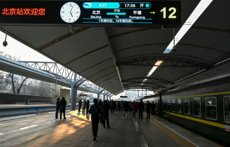 Des voyageurs montent à bord du train K27 à destination de Pyongyang, à la gare de Pékin, le 12 mars 2026 en Chine ( AFP / ADEK BERRY )