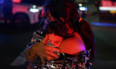 Une mère enveloppée avec son enfant dans une couverture de survie après l'attaque contre une fête juive sur la plage de Bondi, à Sydney, qui a fait onze morts et 29 blessés, le 14 décembre 2025 ( AFP / DAVID GRAY )