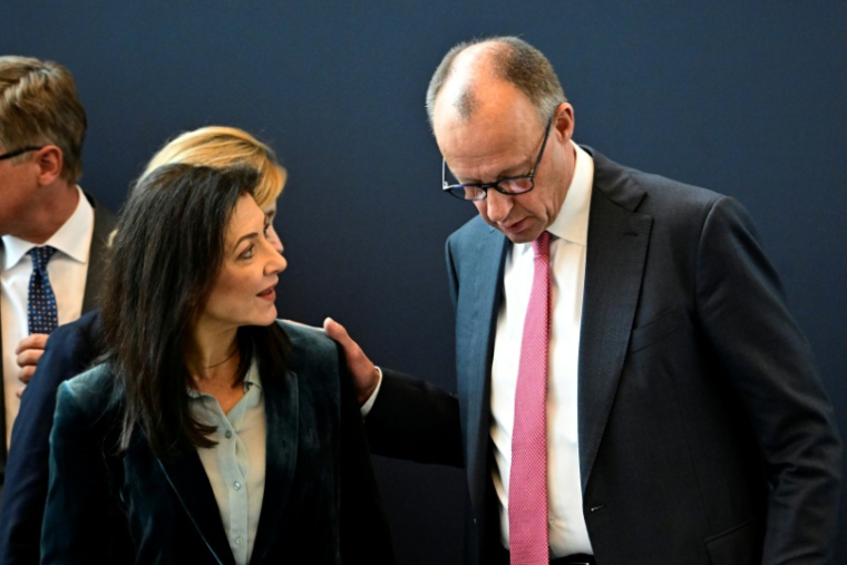 Le chancelier allemand Friedrich Merz parle à la ministre de l'Economie Katherina Reiche, 13 avril 2026 ( AFP / Tobias SCHWARZ )