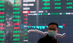 Un homme portant un masque de protection est vu à l'intérieur du bâtiment de la Bourse de Shanghai