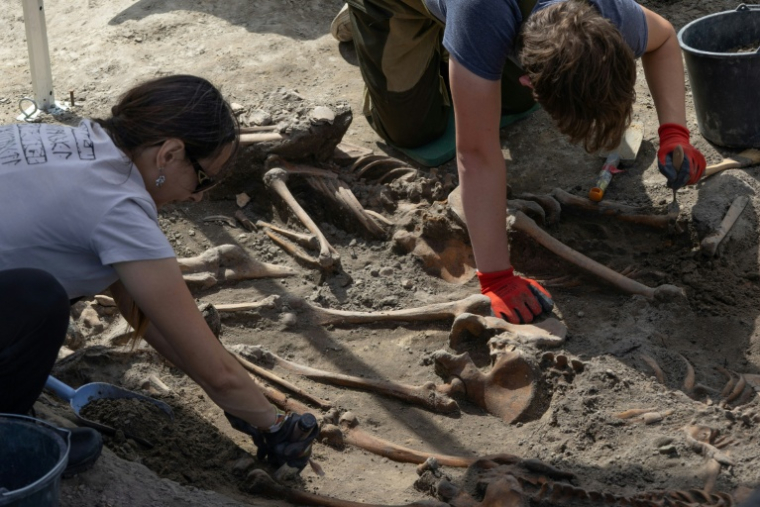 Des archéologues exhument des restes humains sur le site d’exhumation du massacre de Volhynie de la Seconde Guerre mondiale, près du village détruit d’Ostrivky, dans la région de Volyn, le 28 juillet 2026. Les restes d’au moins 49 victimes de massacres de la Seconde Guerre mondiale ont été mis au jour ( AFP / Serhii Okunev )