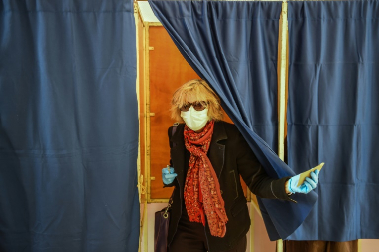 Une femme portant un masque sort d'un isoloir lors du premier tour des élections municipales, le 15 mars 2020 à Bordeaux ( AFP / NICOLAS TUCAT )