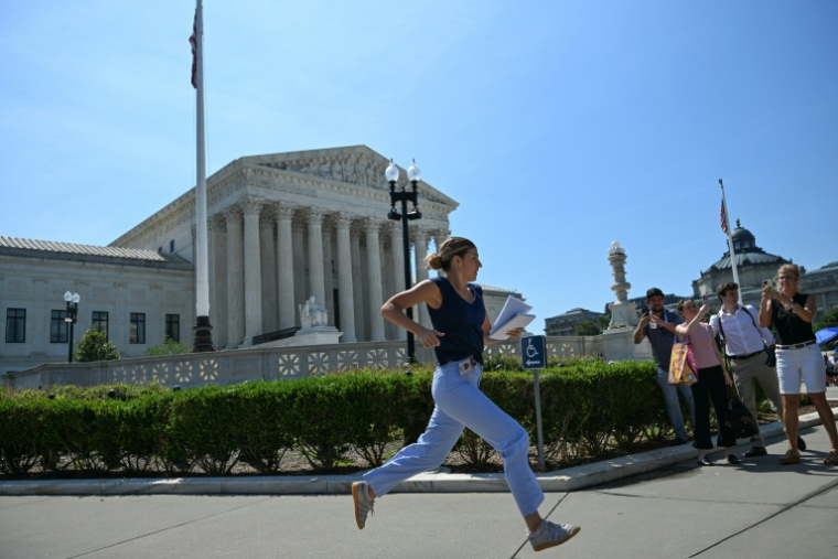 Une employée de médias court pour apporter les décisions de la Cour suprême des Etats-Unis, à Washington le 30 juin 2026 ( AFP / Alex WROBLEWSKI )
