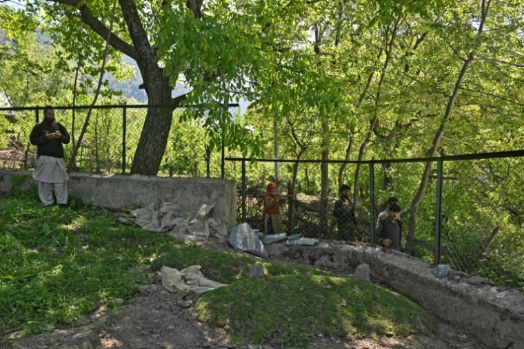 Un membre de la famille prie sur la tombe de Syed Adil Shah, tué dans l'attaque meurtrière de Pahalgam, le 29 avrl 2025 à Hapatnar, dans le district d'Anantnag, au Cachemire indien ( AFP / Tauseef MUSTAFA )