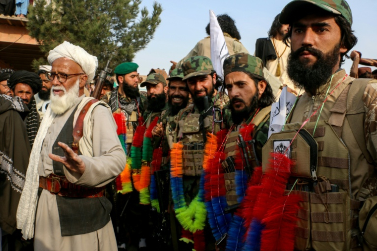 Des Afghans accueillent des soldats avec des guirlandes colorées pour marquer leur soutien aux troupes talibanes qui combattent le Pakistan, à Gurbuz, dans la province de Khost, le 4 mars 2026  ( AFP / STR )