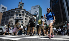 Des piétons dans une rue du quartier de Ginza à Tokyo où les températures ont dépassé les 34°C, le 18 juin 2025 ( AFP / Philip FONG )