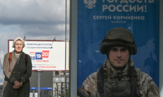 Une passante près d'une affiche faisant la promotion de l'armée russe en Ukraine sur laquelle on peut lire "Fierté de la Russie", à Moscou le 15 septembre 2026 ( AFP / Igor IVANKO )