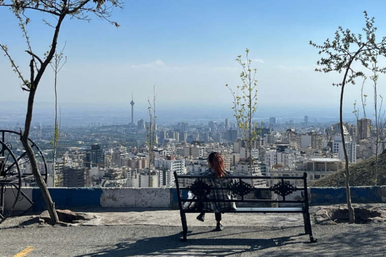 Une femme assise sur un banc au parc Pardisan, surplombant Téhéran, le 22 avril 2026 en Iran ( AFP / - )