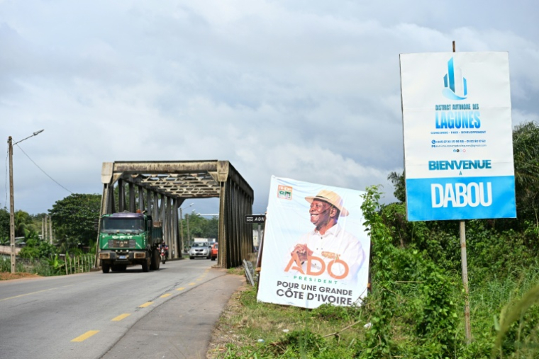 Une affiche de campagne du président ivoirien et candidat à la présidentielle du Rassemblement des houphouétistes pour la démocratie et la paix (RHDP) Alassane Ouattara, à l'entrée de la ville de Dabou, le 16 octobre 2025 en Côte d'Ivoire ( AFP / Sia KAMBOU )