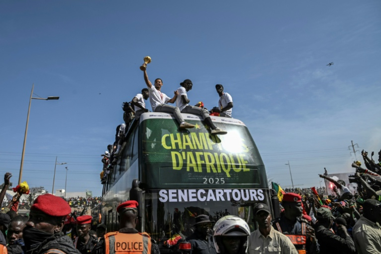 Les Sénagalais champions d'Afrique présentent leur trophée à la foule de Dakar, mardi 20 janvier 2026. ( AFP / NICOLAS REMENE )
