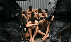 Des policiers gardent des délinquants présumés arrêtés lors de l'opération Contenção (opération Confinement) dans la favela Vila Cruzeiro, dans le complexe Da Penha, à Rio de Janeiro, au Brésil, le 28 octobre 2025 ( AFP / Mauro PIMENTEL )