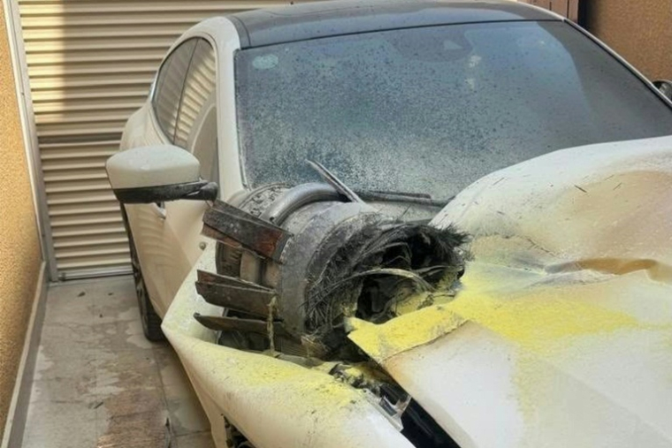 Photo diffusée par l'Agence de presse saoudienne (SPA) le 14 octobre 2026 montrant les restes d'un projectile sur le toit d'un véhicule endommagé, dans un immeuble résidentiel à Riyad après une frappe ( SPA / Ahmed NURELDINE )