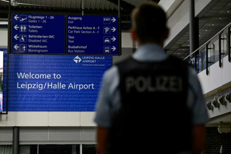 Un policier à l'aéroport de Leipzig après la découverte d'un drone chargé d'explosifs, attribué par l'Allemagne à Moscou, près d'un avion cargo ukrainien, le 5 août 2026 ( AFP / John MACDOUGALL )