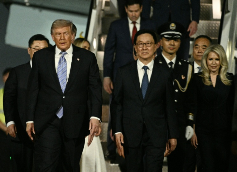 Le président américain Donald Trump descend de l'Air Force One et est accueilli par le vice-président chinois Han Zheng à son arrivée à l'aéroport international de Pékin, le 13 mai 2026 ( AFP / Brendan SMIALOWSKI )