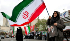 Une femme tient une photo du nouveau guide suprême iranien, Mojtaba Khamenei, et un drapeau national sur la place Enghelab à Téhéran, le 25 mars 2026 ( AFP / - )