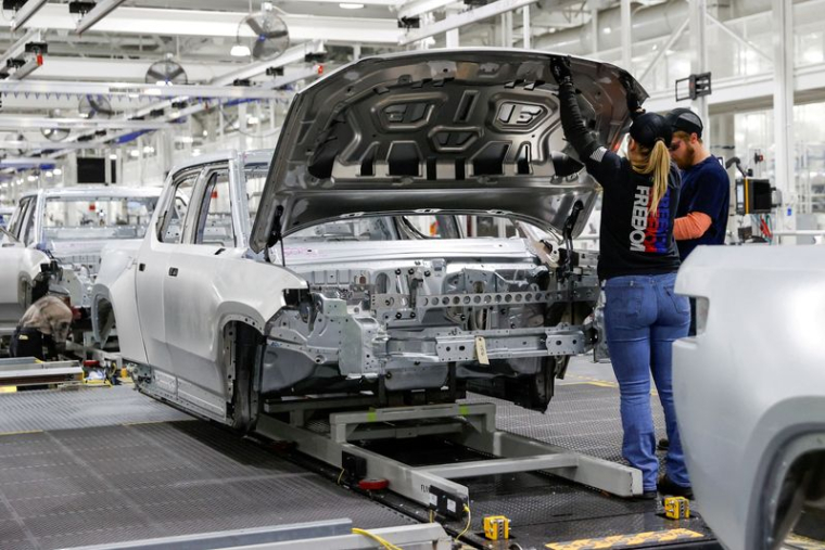 Des employés travaillent sur une chaîne de montage dans l'usine de véhicules électriques de la startup Rivian Automotive à Normal, Illinois