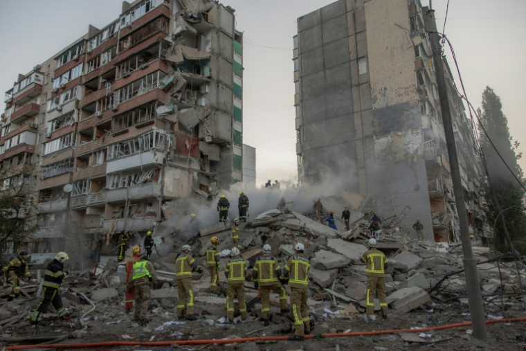 Des secouristes dans les décombres d'un immeuble résidentiel touché par des frappes de drones et de missiles russes sur un immeuble résidentiel à Kiev, le 14 mai 2026 en Ukraine ( AFP / Roman PILIPEY )