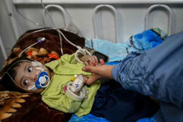 Un enfant malnutri tient la main de sa mère dans le centre de Médecins Sans Frontières (MSF) d’un hôpital à Hérat le 8 janvier 2026 ( AFP / Wakil KOHSAR )