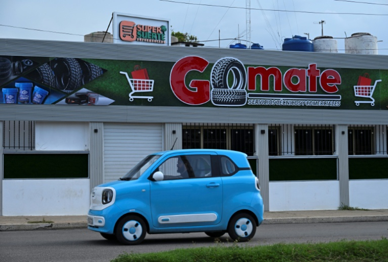 Une voiture électrique passe devant un magasin privé à La Havane, le 22 juin 2026 ( AFP / YAMIL LAGE )