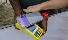 Une femme règle un achat sur la plage de Copacabana à l'aide du système de paiement instantané brésilien PIX, à Rio de Janeiro, le 9 juillet 2026 au Brésil ( AFP / Pablo PORCIUNCULA )