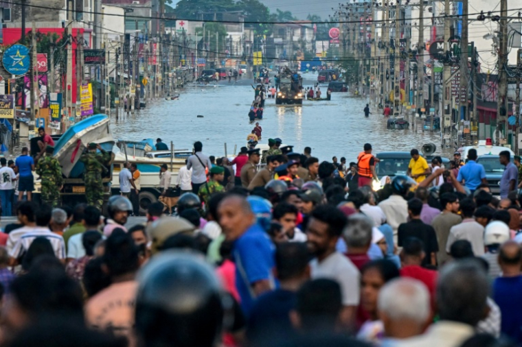 Des militaires à bord d'un camion transportent des bateaux de secours pour les habitants bloquées sur une route inondée après de fortes pluies à Wellampitiya, en périphérie de Colombo, le 30 novembre 2025 au Sri Lanka ( AFP / Ishara S. KODIKARA )