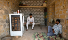 Deux hommes devant un climatiseur, par 42°C, le 29 mai 2026 à Sanwata, au Rajasthan, en Inde ( AFP / Manan VATSYAYANA )