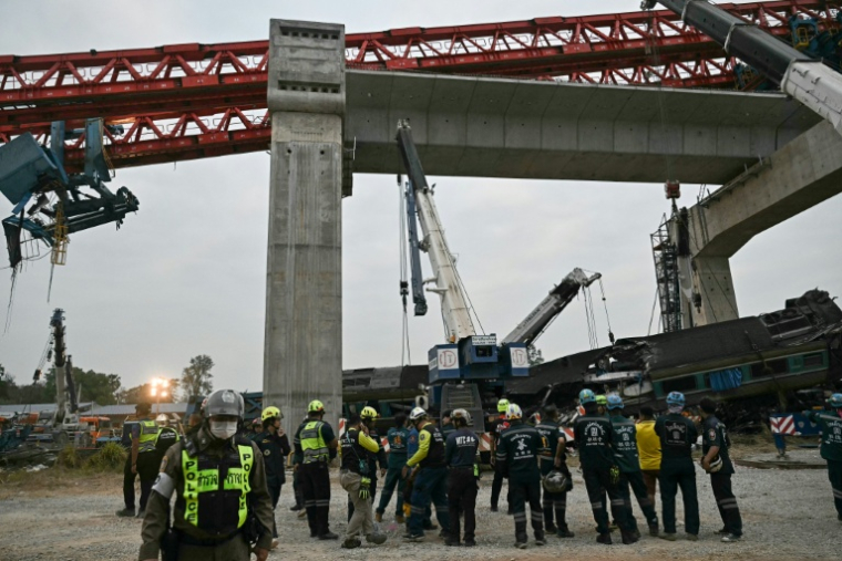 Des secouristes sur le site du déraillement d'un train provoqué par l'effondrement d'une grue de chantier dans la province de Nakhon Ratchasima, en Thaïlande, le 14 janvier 2026 ( AFP / Lillian SUWANRUMPHA )